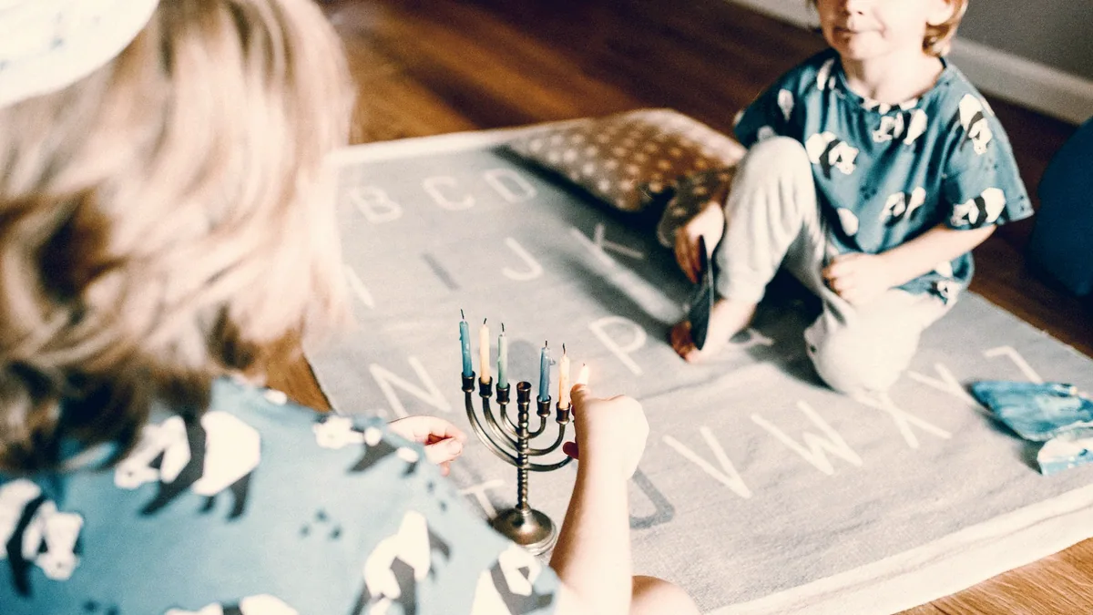 Des enfants dessinent autour d'une table, à la maison.