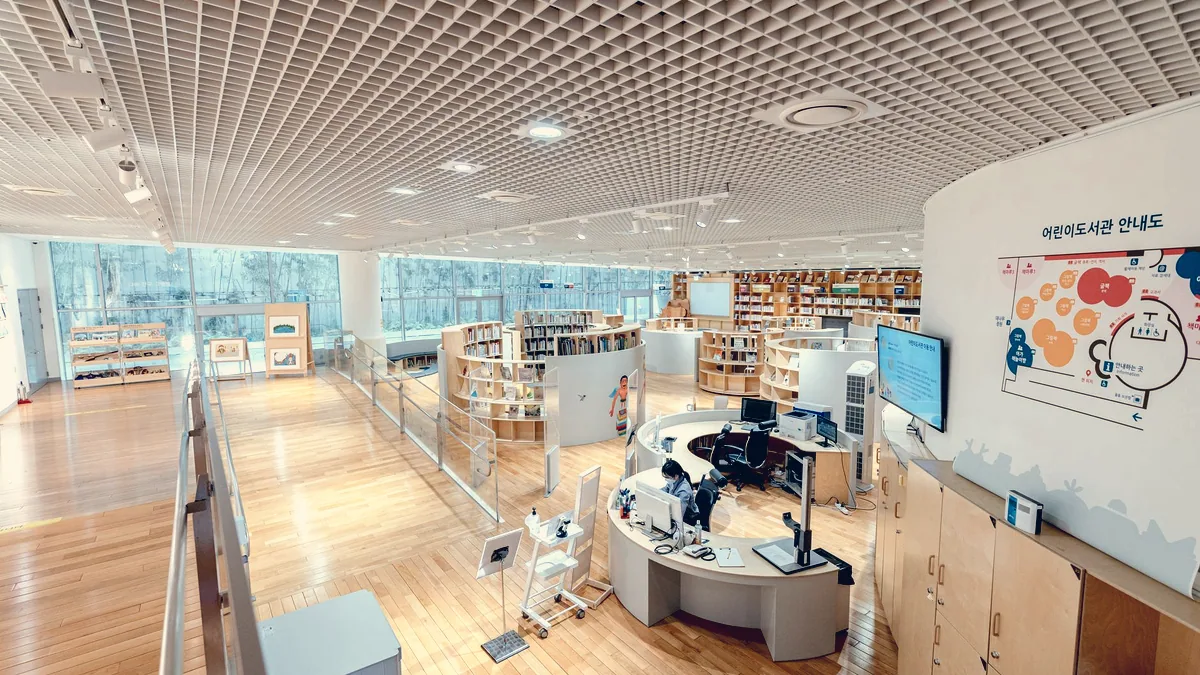 Une allée de bibliothèque publique, entre les rayonnages.