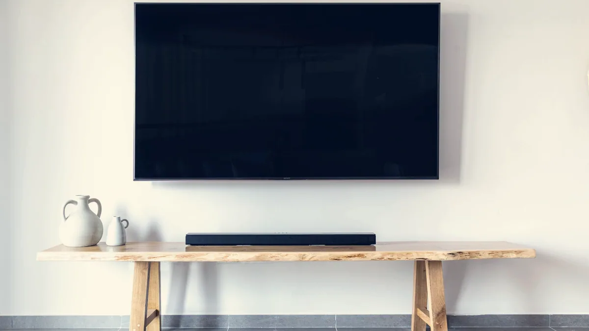Un écran de télévision fixé au mur, éteint.